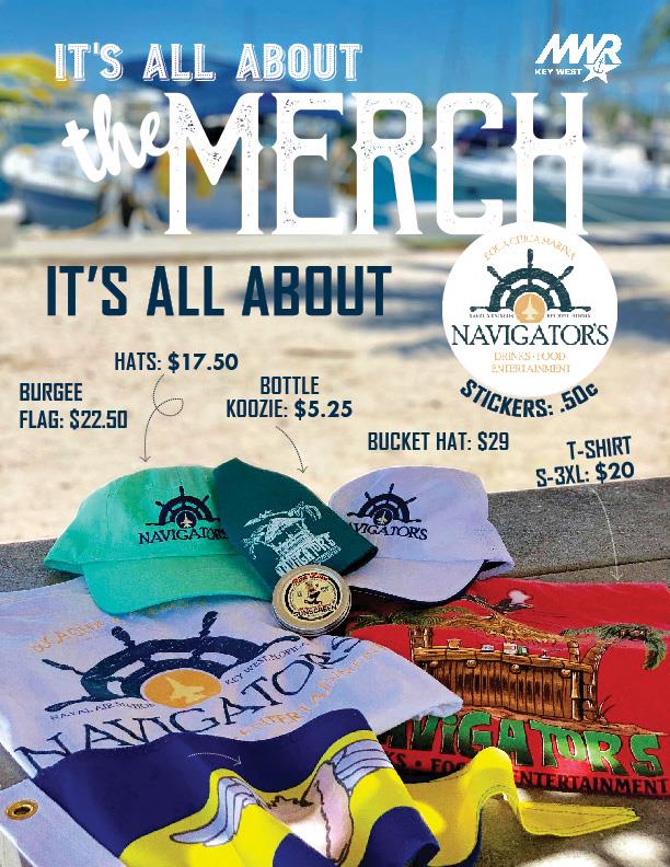 Merchandise display on a beach for Navigator's Bar featuring colorful hats (\$17.50), bucket hat (\$29), t-shirts sizes S–3XL (\$20), burgee flag (\$22.50), bottle koozie (\$5.25), and stickers (\$0.50), with boats and sand in the background.